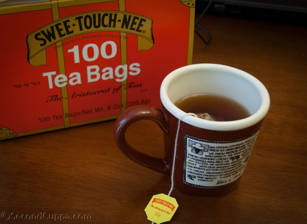 Image of the Swee-Touch-Nee Tea Pacakge with a Cup Brewing in the Foreground