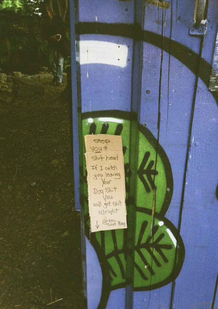 "Stop you shit head. If I catch you leaving your dog shit, you will get shit alright. Green shit bag."