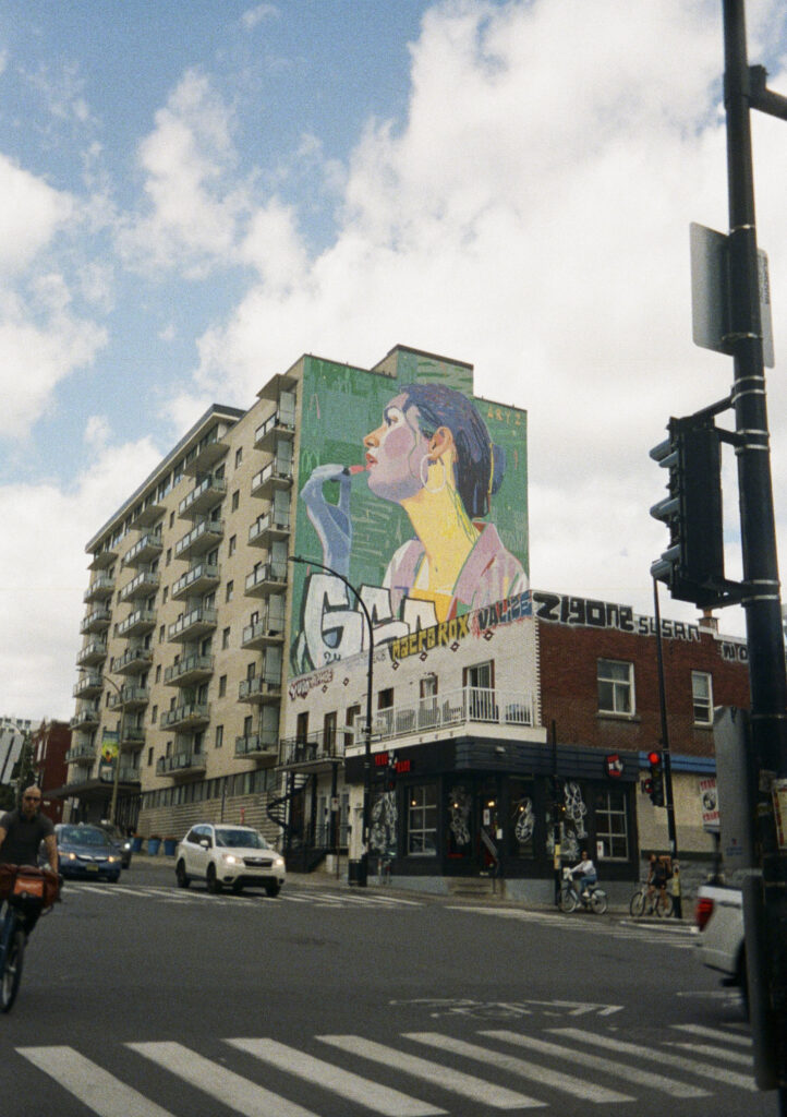 Mural of a woman putting on lipstick.