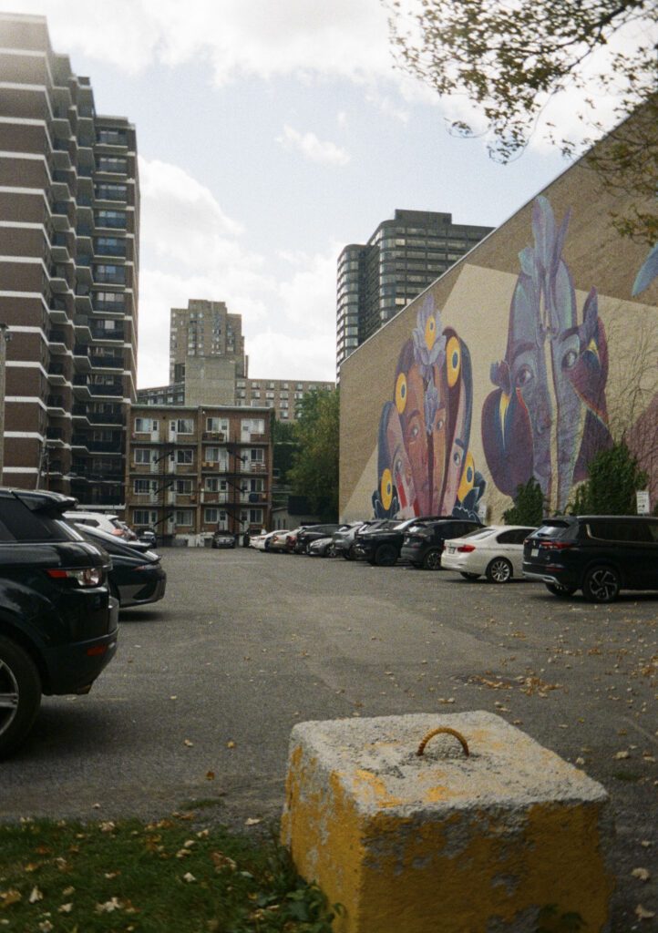 Mural on the side of a building in a parking lot.